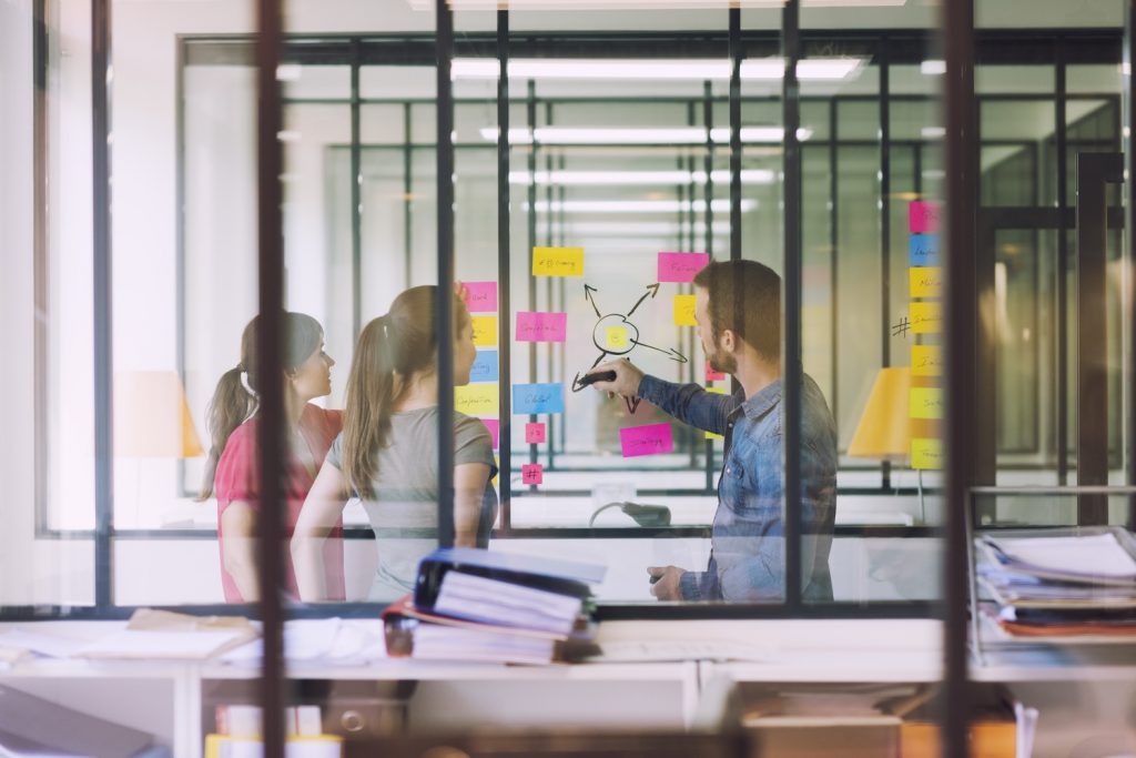 Equipe agile devant un mur tableau effaçable